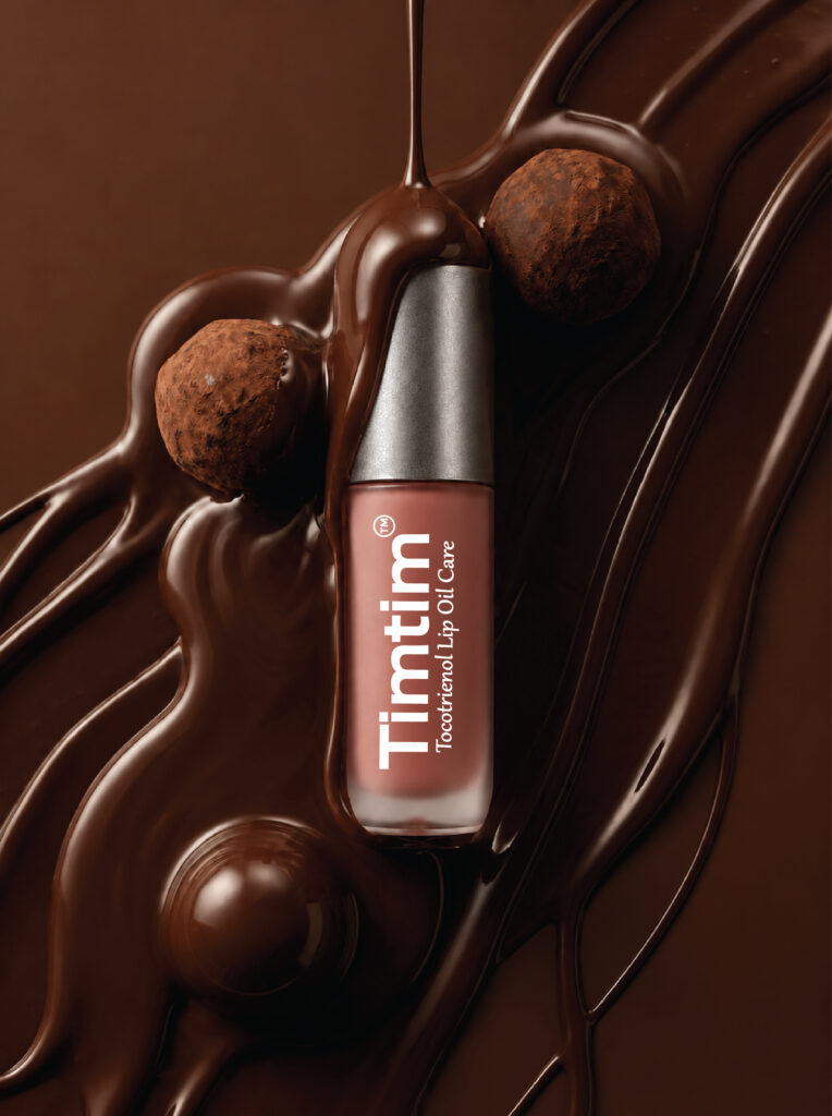 Timtim Chocolate lip oil cream with a Titanium cap surrounded by melted chocolate and truffles